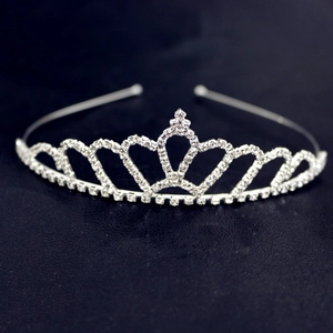 Detailed close-up of a silver crown headband with heart-shaped crystal patterns