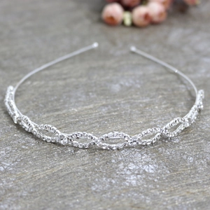 Detailed view of silver wavy rhinestone headband with sparkling crystal chain design