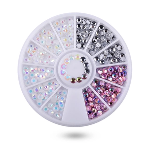 Macro view of multi-color AB acrylic nail art rhinestones in a white plastic wheel box