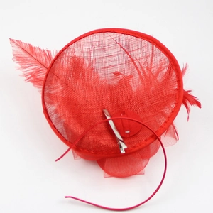 Detail view of red fascinator hat featuring delicate feathers and silver metal hair clip