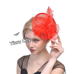 Detail of red bridal fascinator with elegant feathers and mesh flower on a model
