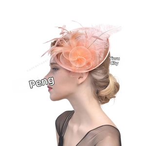 Close-up of peach mesh pillbox hat with elegant floral folds and feather accents