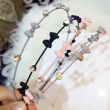 Dettaglio di cerchietti con orecchie da gatto, fiocchi e strass in grigio, nero e rosa