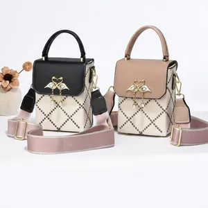 Detailed close-up of quilted cross-body bag featuring a pearl-studded metal swan buckle