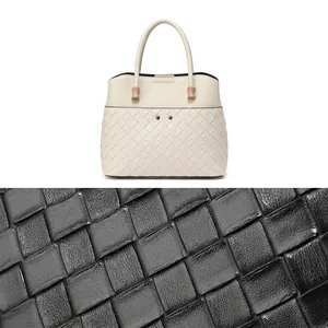 Close-up of premium woven leather texture and elegant metallic hardware on crossbody bag