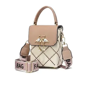 Detail of elegant two-tone crossbody bag with swan metal clasp and pearl tassel charm