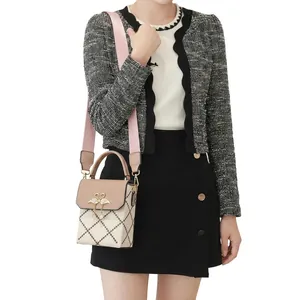 Detail of quilted beige bag with gold swan buckle, pearl tassel and wide strap