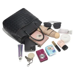 Detail view of black woven leather tote showing spacious capacity for phone and accessories