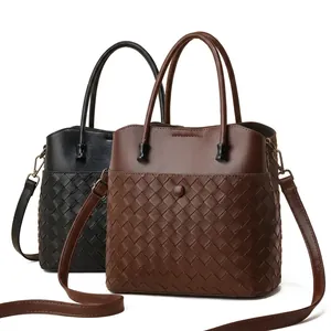 Detail of woven leather tote bag texture with adjustable strap and smartphone size comparison