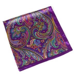 Detail of silk-like paisley square scarf featuring vibrant patterns and purple satin borders