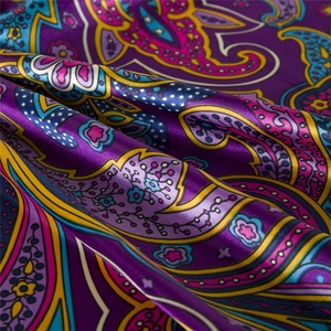 Detail of silk satin scarf with purple bohemian paisley patterns and glossy texture