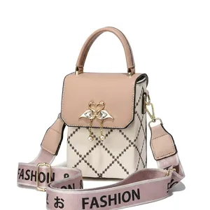 Detail of khaki and beige crossbody bag featuring swan buckle and pearl tassel charm