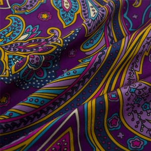 Detailed macro view of purple bohemian paisley pattern on silky satin square scarf
