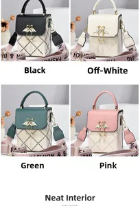 Detail view of quilted handbags in black, cream, green and pink with pearl swan buckles