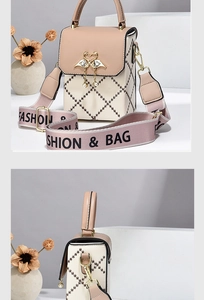 Detail view of two-tone quilted mini bag featuring a swan clasp and pearl pendant decoration