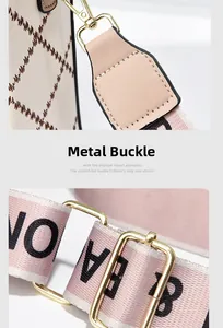 Close-up of golden metal buckle and woven shoulder strap on minimalist beige crossbody bag