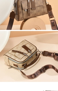 Detail van vintage bruine crossbodytas met logopatroon, brede riem en kettingaccenten
