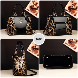 Detail view of leopard print handbag with gold logo, back zipper, and protective bottom studs