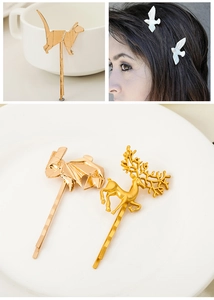 Gold origami style cat and rabbit alloy hair clips set on a decorative white dish