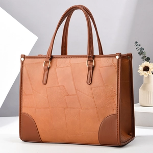 Brown patchwork tote bag with stitched leather panels and rounded top handles