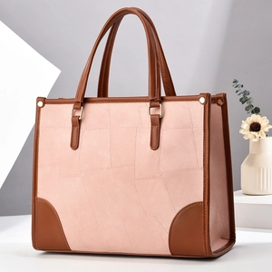Pink matte leather tote bag with geometric stitching and brown contrast leather accents