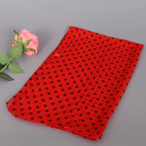 Macro shot of red chiffon scarf with black polka dots featuring light sheer texture