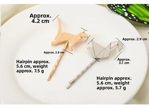 Detail of geometric origami cat and swan metal hairpins with size dimensions on white plate