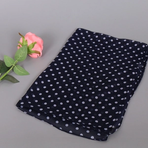 Detailed macro view of navy blue chiffon scarf fabric featuring a white polka dot pattern