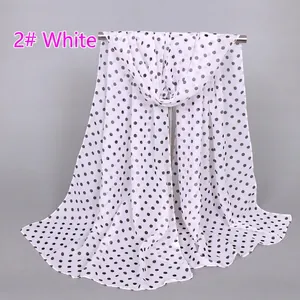 Close-up detail of white chiffon scarf with black polka dots and lightweight texture