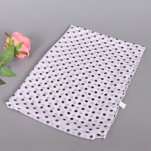 Detailed view of lightweight white chiffon scarf with classic black polka dot pattern