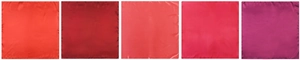 Detail view of smooth silk satin square scarves in various shades of elegant red colors