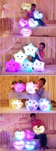 Detail of colorful glowing star, heart and paw plush pillows with soft LED lighting