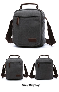 Detail view of multi-pocket grey canvas messenger bag with leather handle and zip pockets