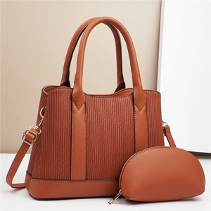 Sac à main marron plissé avec petite pochette assortie dans un décor minimaliste