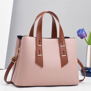 Pink lychee grain leather handbag with brown handles and golden metal detail accents