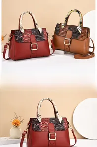 Gros plan du rabat à motif crocodile et du fermoir doré sur le sac à main pour femme