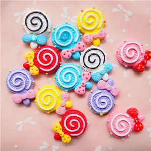 Flat lay of colorful swirl lollipop resin charms with polka dot bows for DIY jewelry