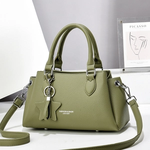 Détail du sac en cuir vert grainé avec lettrage mode et accessoires métalliques dorés