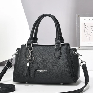 Sac à main minimaliste en cuir noir avec pendentif étoile et bandoulière ajustable