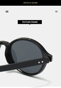 Detailed macro view of black oval sunglass frame featuring polished finish and silver rivets