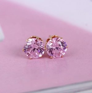 Macro view of 8mm pink zircon stud earrings with gold six-prong setting detail
