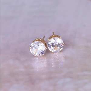 Detailed macro view of 8mm round zircon stud earrings with elegant gold six-prong setting