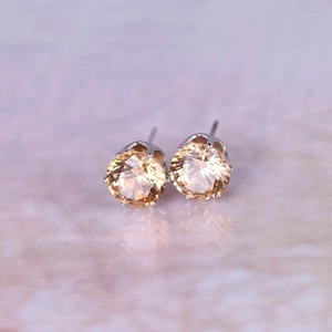 Close-up of 8mm champagne round cubic zirconia stud earrings with silver prong setting