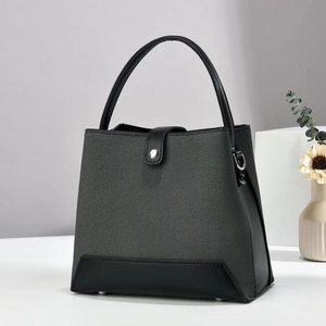 Sac à main bicolore gris et noir minimaliste avec poignées en cuir sur support