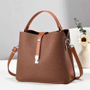 Nahaufnahme der braunen Stoff- und Kunstleder-Strukturdetails an der Eimer-Tasche