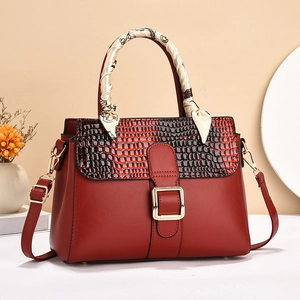 Sac à main en cuir rouge avec rabat motif crocodile et poignée décorée d'un foulard