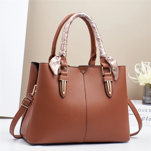 Chic brown pebbled leather handbag with decorative silk scarf handle and long strap