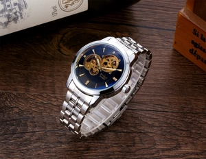 Detail of BYINO mechanical watch featuring a blue skeleton dial and silver metal strap