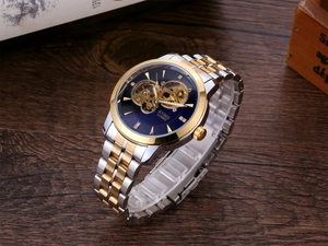 Close-up of skeleton automatic watch with blue dial and gold-silver steel bracelet