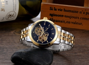 Close-up of BXNO automatic mechanical watch with skeleton blue dial on dark stones